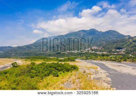 landscape of golden miscanthus with mountain and river under sky