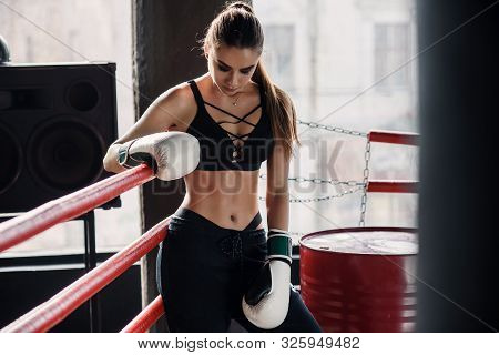 Tired Sports Girl Leaned On Red Ropes On Boxing Ring, And Have A Rest After Hard Training In Black L