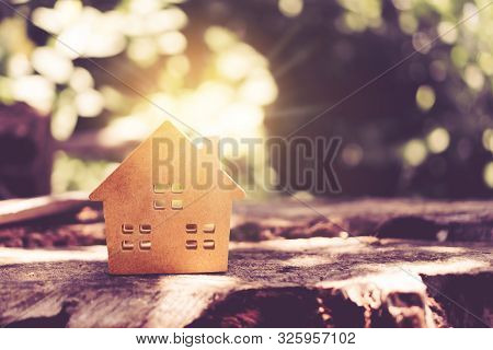 Closed Up Tiny Home Model On Floor Or Wood Board With Sunlight Green Bokeh Background. Deam Life Hav