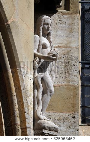 ROTHENBURG, GERMANY - JULY 16, 2019: Eve with snake, statue on facade of the St James Church in Rothenburg ob der Tauber, Germany