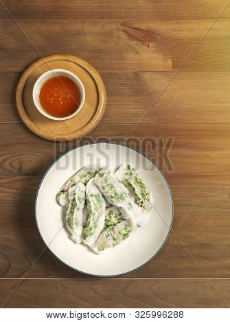 Top View Vietnamese Steamed Rice Dumplings Served With Spicy Chili Sauce Over Wooden Table