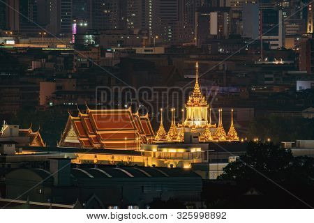 Loha Prasat, Wat Ratchanatda, And Skyscraper Buildings At Night In Bangkok City, Thailand. Buddhist 