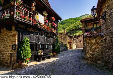Picturesque Stone Houses With Black Wooden Facade And Narrow Stone Alley. Barcena Mayor Santander.