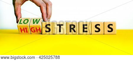 Low Or High Stress Level Symbol. Businessman Turns Wooden Cubes And Changes Words High Stress To Low