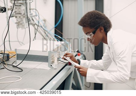 Scientist African American Woman Working In Laboratory With Electronic Tech Single Photon Detector. 
