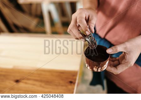 Close-up Imege Of Female Carpenter Soaking Binder Clip With Piece Of Cloth In Jar With Oil To Cover 