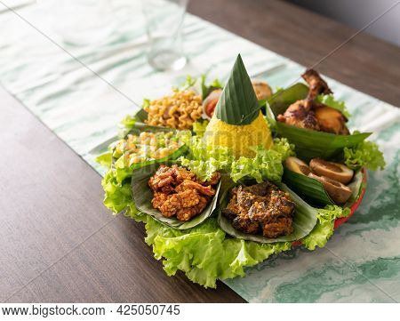 Nasi Tumpeng. Indonesian Cuisine Yellow Rice On Banana Leaf