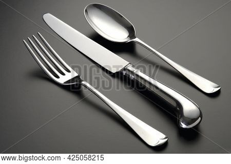 A Closeup Shot Of Silver Utensils Set Isolated On A Black Surface
