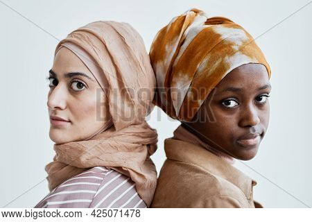 Close Up Portrait Of Two Ethni Young Women Standing Back To Back And Wearing Traditional Clothing