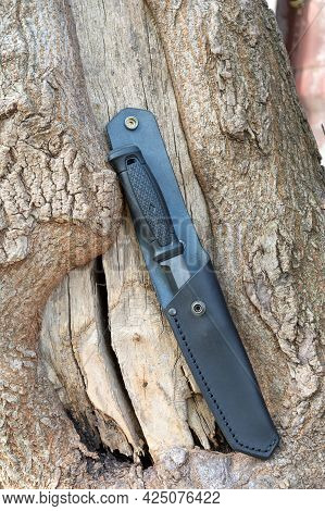 A Knife In A Leather Sheath. Hunting Knife In A Leather Case. Knife On A Wooden Background.vertical 
