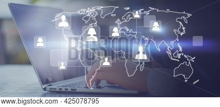 Close Up Of Hands Using Laptop And Smartphone With Glowing Map And People Icons. Social Media And On