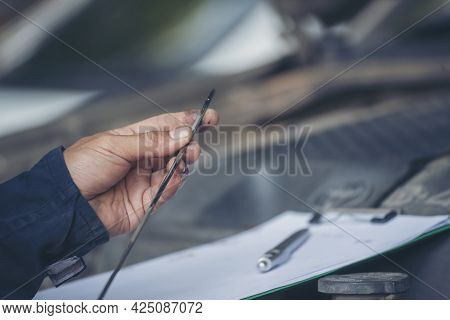 Car Mechanic Man Hand Checking Dipstick Engine Oil Car Mechanical On Site Service. Close Up Hand Man