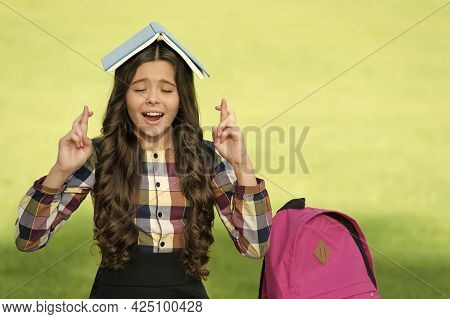 I Dont Want To Jinx It. Superstitious Child Make Wish Holding Book On Head. Victim Of Superstition. 