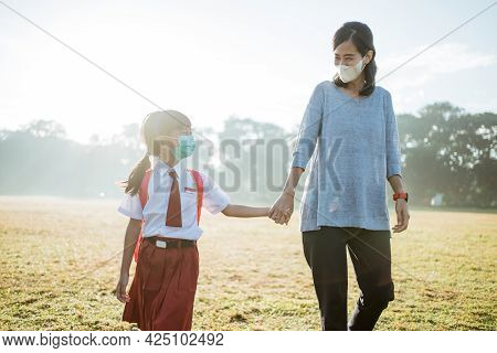 Mother And Her Daughter Walking Together And Wear Face Mask