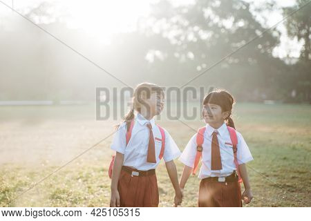 Happy Female Asian Primary School Student Walk Together
