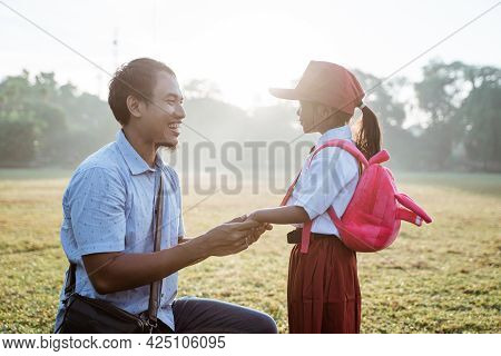 Father Taking Her Daughter To Primary School In The Morning