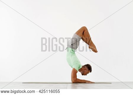 Sporty Young Man Doing Backbend Handstand, Yoga, Pilates, Fitness Training, Standing In Chin Balance