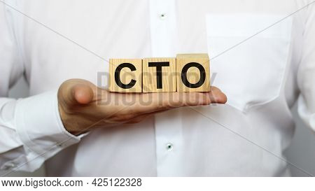 A Businessman Holds Wooden Cubes With A Word Cto On A White Background, With Space To Copy The Text,