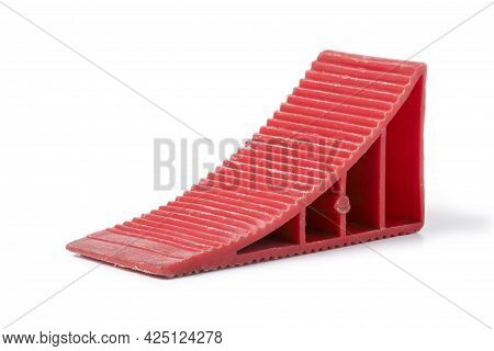 Red Wheel Chock Under The Wheel Of A Car Close-up