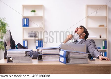 Young male employee working at workplace during pandemic