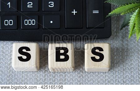 Sbs - Acronym On Wooden Cubes On A Gray Background With A Calculator. Business Concept