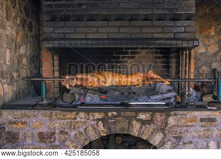 Baking Whole Goat At Roasting-jack On Fire. Traditional Albanian Dish.
