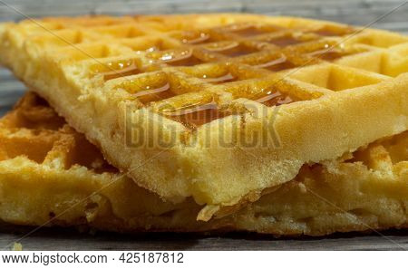 Freshly Baked Waffles In Syrup For Breakfast. Closeup.