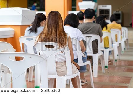 Back View Of People Sitting Waiting To Get The Covid-19 Vaccine