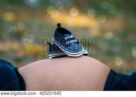 Photos Of A Pair Of Tiny Shoes On A Pregnant Woman's Tummy