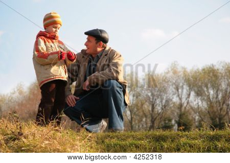 Großvater und Enkel sitzen auf einer Anhöhe