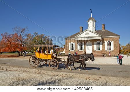 Gite in carrozza trainata da cavalli davanti all'edificio del Palazzo di giustizia In Colonial Williamsburg, Virginia,