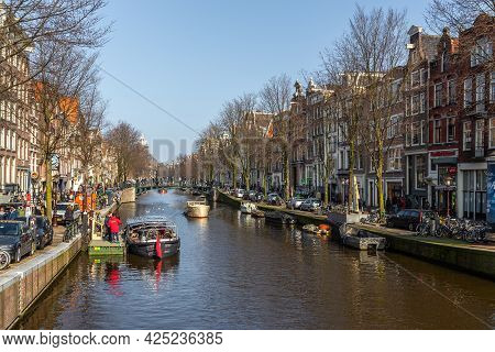 Amsterdam, Netherlands -12 March 2016: Boats On The Amstel Canal And People Walking Around. Bridge O