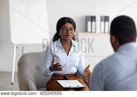 Psychological Counseling. Professional Female Psychotherapist Having Session With Young Black Guy At