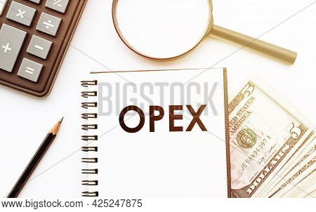 White Notepad With The Text Of The Opex Operational Expenditures On The Background Of Dollars And Of