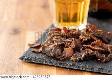 Sliced beef jerky. Dried beef meat on wooden table.