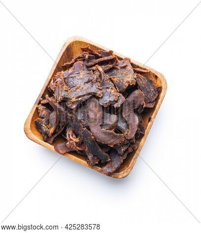 Sliced beef jerky. Dried beef meat in bowl isolated on white background.