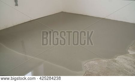 Workers Level The Floor With Mortar. Self-priming Liquid Floor. Adjust The Mixed Cement In The Mold.