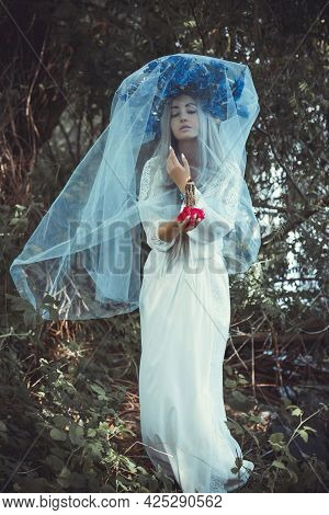 Beautiful Girl In Wreath Of Flowers In Forest. Portrait Of Young Beautiful Woman Wearing White Bride