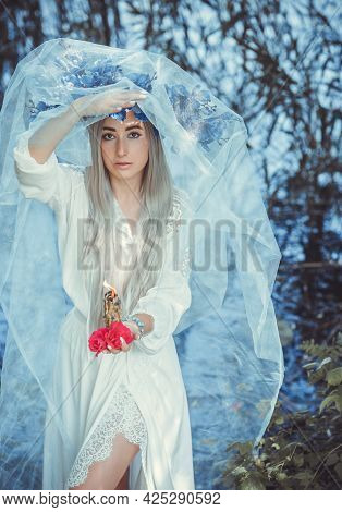 Beautiful Girl In Wreath Of Flowers In Forest. Portrait Of Young Beautiful Woman Wearing White Bride