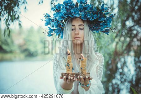 Beautiful Girl In Wreath Of Flowers In Forest. Portrait Of Young Beautiful Woman Wearing White Bride