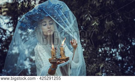 Beautiful Girl In Wreath Of Flowers In Forest. Portrait Of Young Beautiful Woman Wearing White Bride