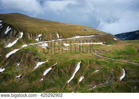 Beautiful scenic view in a rainy and cloudy day over the Transalpina road, the highest mountain road in the Carpathians located in the Parang mountains, Romania, Europe