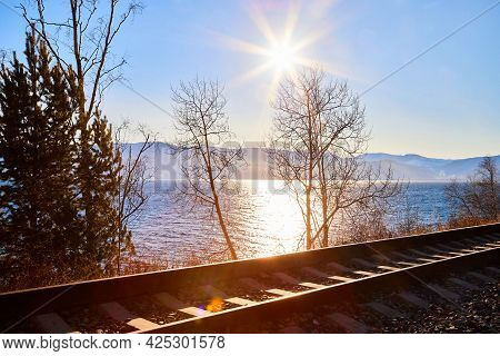 Circum Baikal Railway Running Along The Shore Of Lake Baikal On An Autumn Sunny Day With A Yellow La
