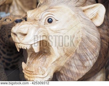 Russia, Sochi 06.06.2021. Wooden Lion With Open Mouth. Roaring Lion. Lion Statuette In Ethnic Style.