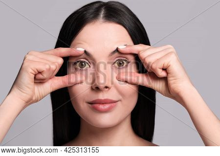 Woman Checking Her Health Condition On Grey Background. Yellow Eyes As Symptom Of Problems With Live