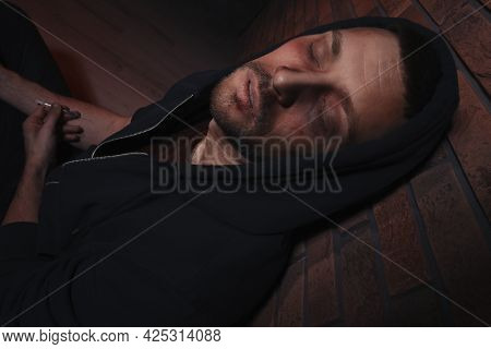 Overdosed Drug Addicted Man Near Brick Wall