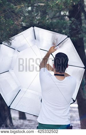 Creative Photographer Back View Adjusting Soft Box Light Intesity.