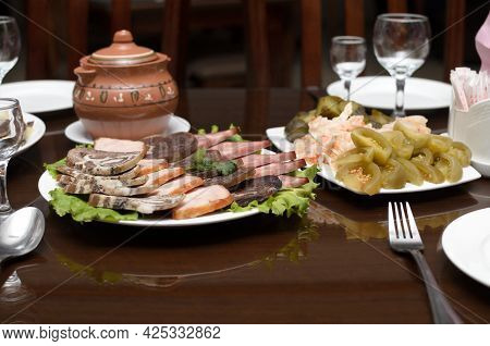 Meat Appetizer Of Smoked Turkey Meat, Beef, Horse Meat Sausage And Pickles, Green Salted Tomatoes, S