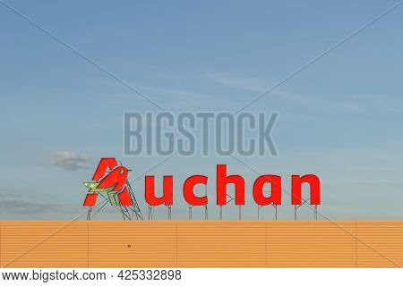 Poland, Warsaw - June 02, 2021: Auchan Advertising Sign On The Roof Of The Hypermarket. Auchan Super