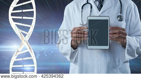 Mid section of male doctor holding a digital tablet against dna structure on purple background. medical research and science technology concept